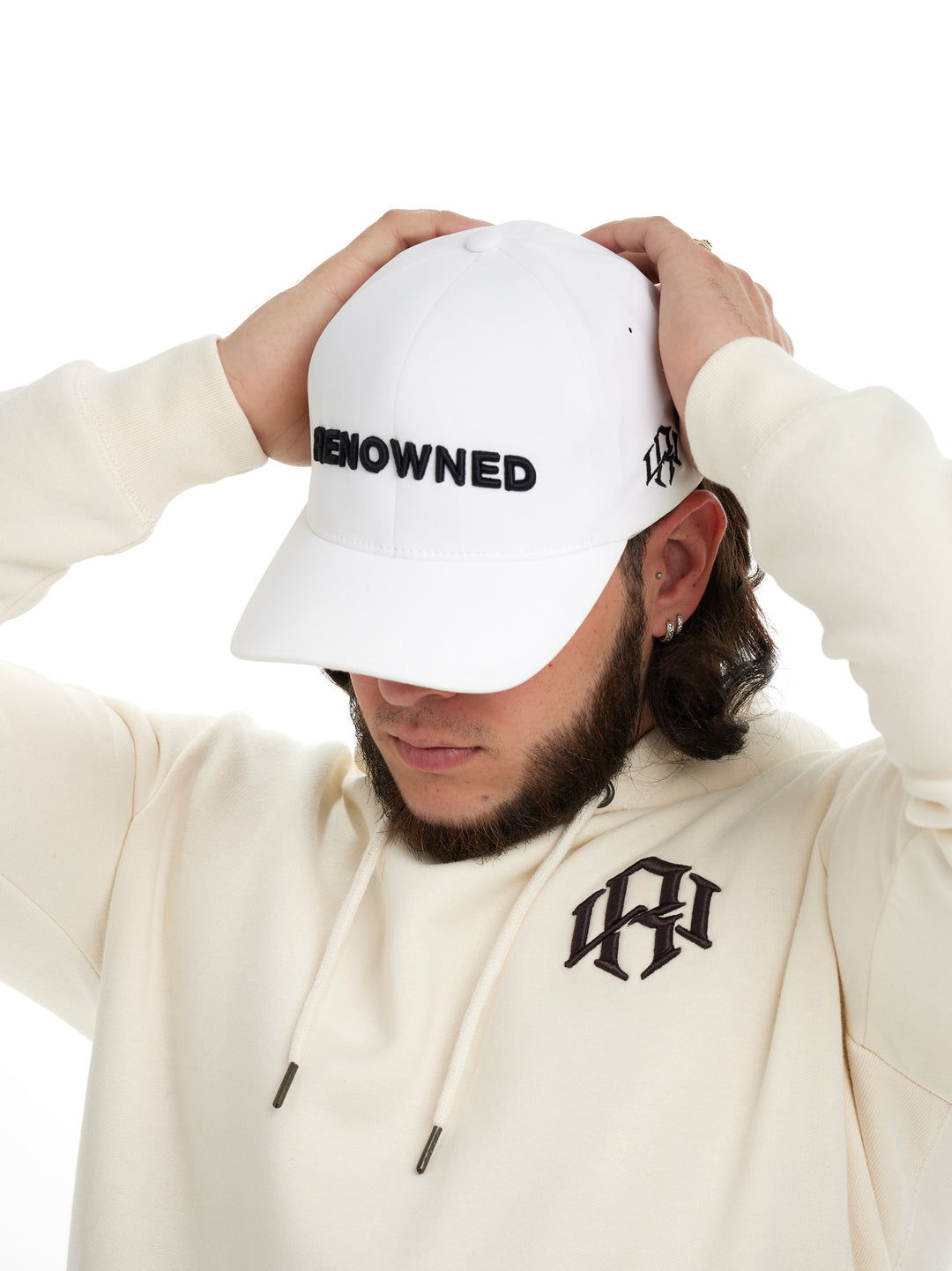 Young man pressed down on his Renowned Wear Core Cap in White