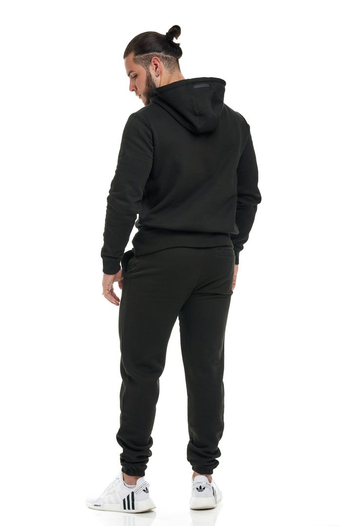 Young man modeling/wearing the Black Colored Premium 400gsm Heavyweight Sweatpants by RENOWNED WEAR